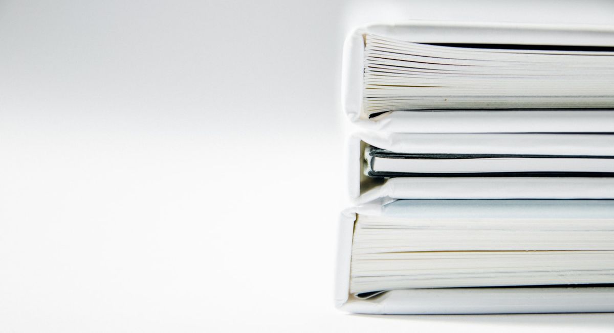 A stack of document folders on a white surface