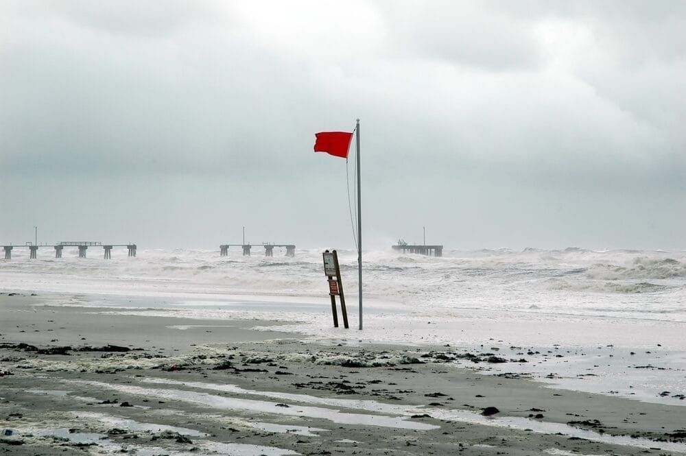 Red flag flying at beach warning of oncoming hurricane